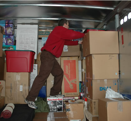 Climbing over the load inside the trailer to arrange items