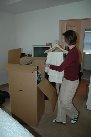 Pam loading a wardrobe box into the trailer