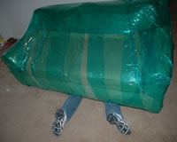 A joke photo of feet sticking out from under a wrapped couch